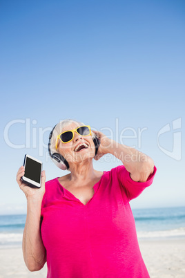 Senior woman listening music with headphone