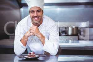 Chef leaning on the counter with a dessert