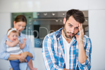 Tensed man with wife and baby in background