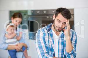 Tensed man with wife and baby in background