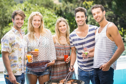 Group of friends preparing barbecue near pool