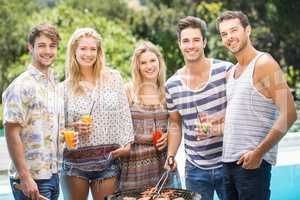 Group of friends preparing barbecue near pool