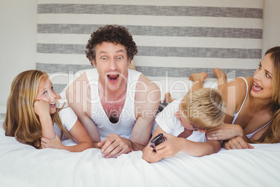 Playful family relaxing on bed