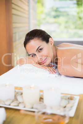 Young woman relaxing on massage table at health spa
