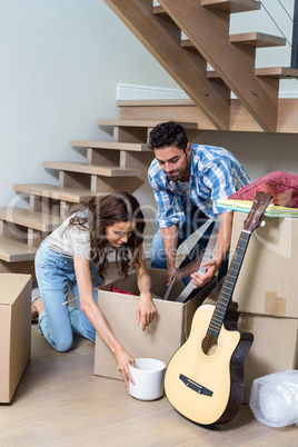 Couple unpacking computer from cardboard box