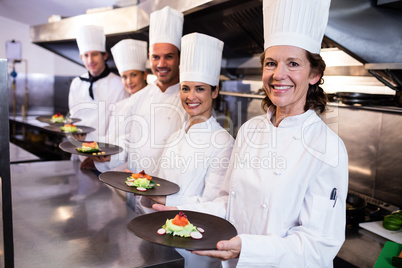 Happy chefs presenting their food plates