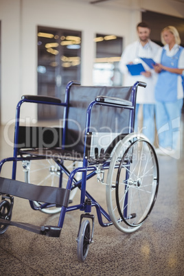 Empty wheelchair with colleagues