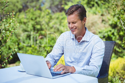 Businessman using laptop with coffee