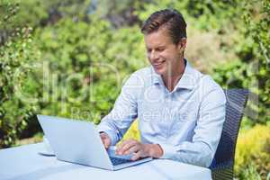 Businessman using laptop with coffee