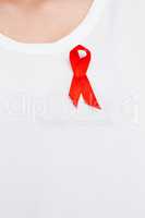 Red aids awareness ribbon pinned on t-shirt