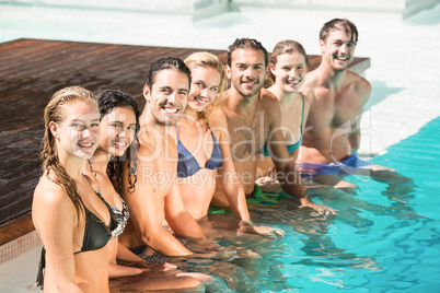 Portrait of friends sitting in swimming pool