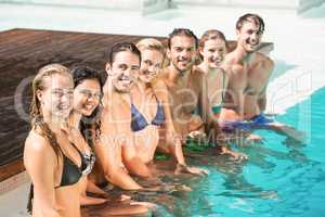 Portrait of friends sitting in swimming pool