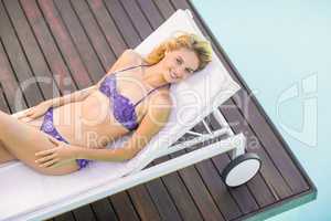 Beautiful young woman relaxing on sun lounger