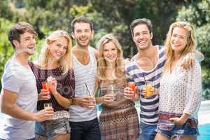 Portrait of friends having juice near pool