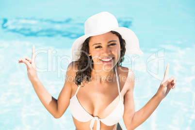 Happy woman in hat having fun by pool side