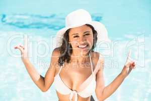 Happy woman in hat having fun by pool side