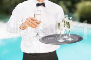 Midsection of waiter offering champagne