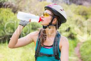 Woman drinking water and wearing helmet