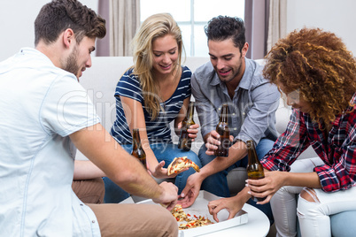 Multi-ethnic friends enjoying beer and pizza