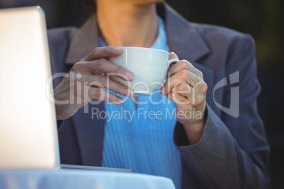 Woman having coffee using her laptop