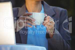 Woman having coffee using her laptop