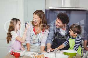 Family enjoying while cooking food in kitchen