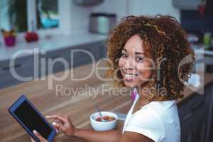 Young woman using digital tablet while sitting by table