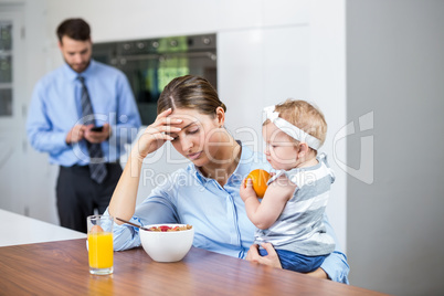 Tensed woman with daughter while husband in background