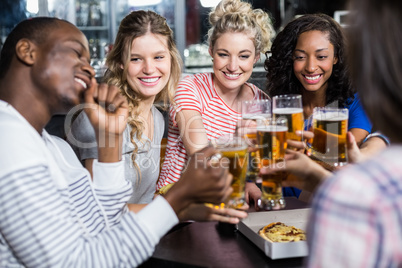 Happy friends having a drink and pizza