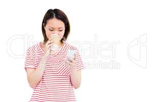 Woman using her mobile phone while drinking coffee