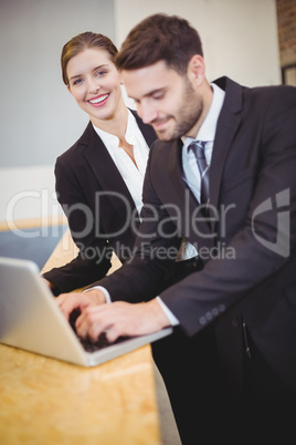 Business people using laptop by counter