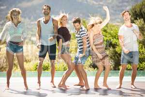 Group of friends dancing at poolside