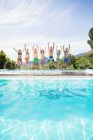 Group of friends jumping at poolside