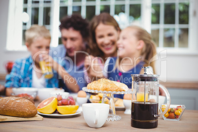 Food on table while happy family in background