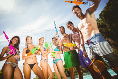 Happy friends standing with water guns