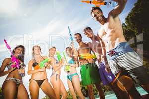 Happy friends standing with water guns