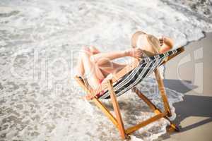 Woman relaxing on an armchair on the beach