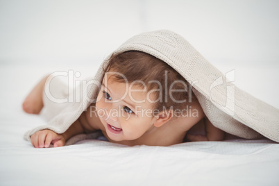 Cute baby lying under blanket