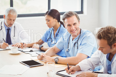 Medical team writing a report in conference room