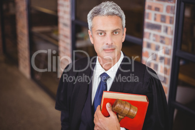 Confident male lawyer with gavel and red book