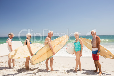 Senior friends holding surfboard