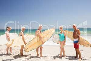 Senior friends holding surfboard