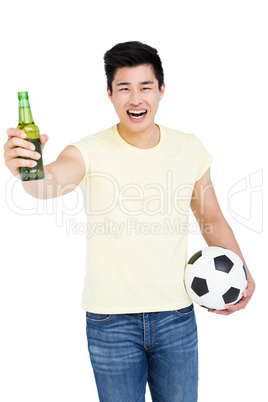 Fan holding a beer bottle and football