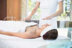 Midsection of masseur massaging woman