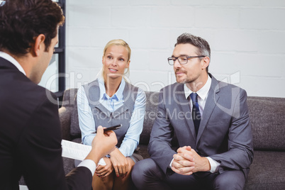 Business people discussing while sitting on sofa