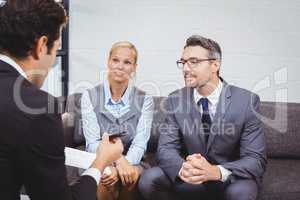 Business people discussing while sitting on sofa