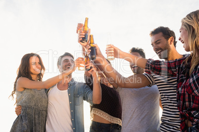 Happy friends raising beer bottles