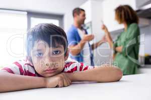 Boy feeling sad while his parents quarrelling