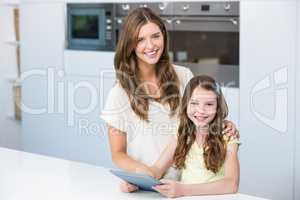 Portrait of mother and daughter with digital tablet