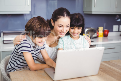 Happy mother and children working on laptop